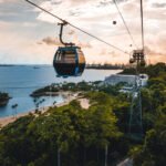 Cableway trip in Sentosa Island, Singapore. Aerial view showing lush green forest and sandy beaches.